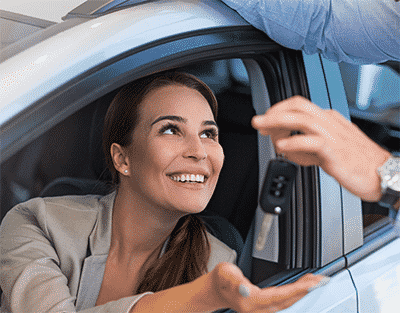 Image of locksmith handing a client her car keys after getting her back in her car.